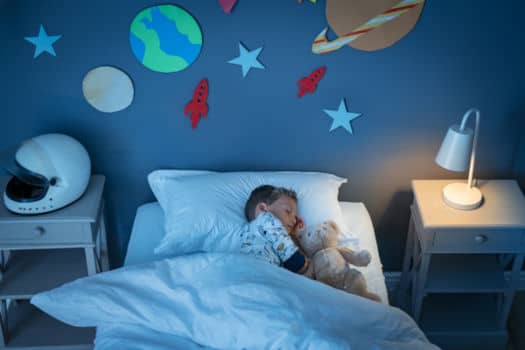 Photo of a boy sleeping in bed after the children's bedroom remodel.